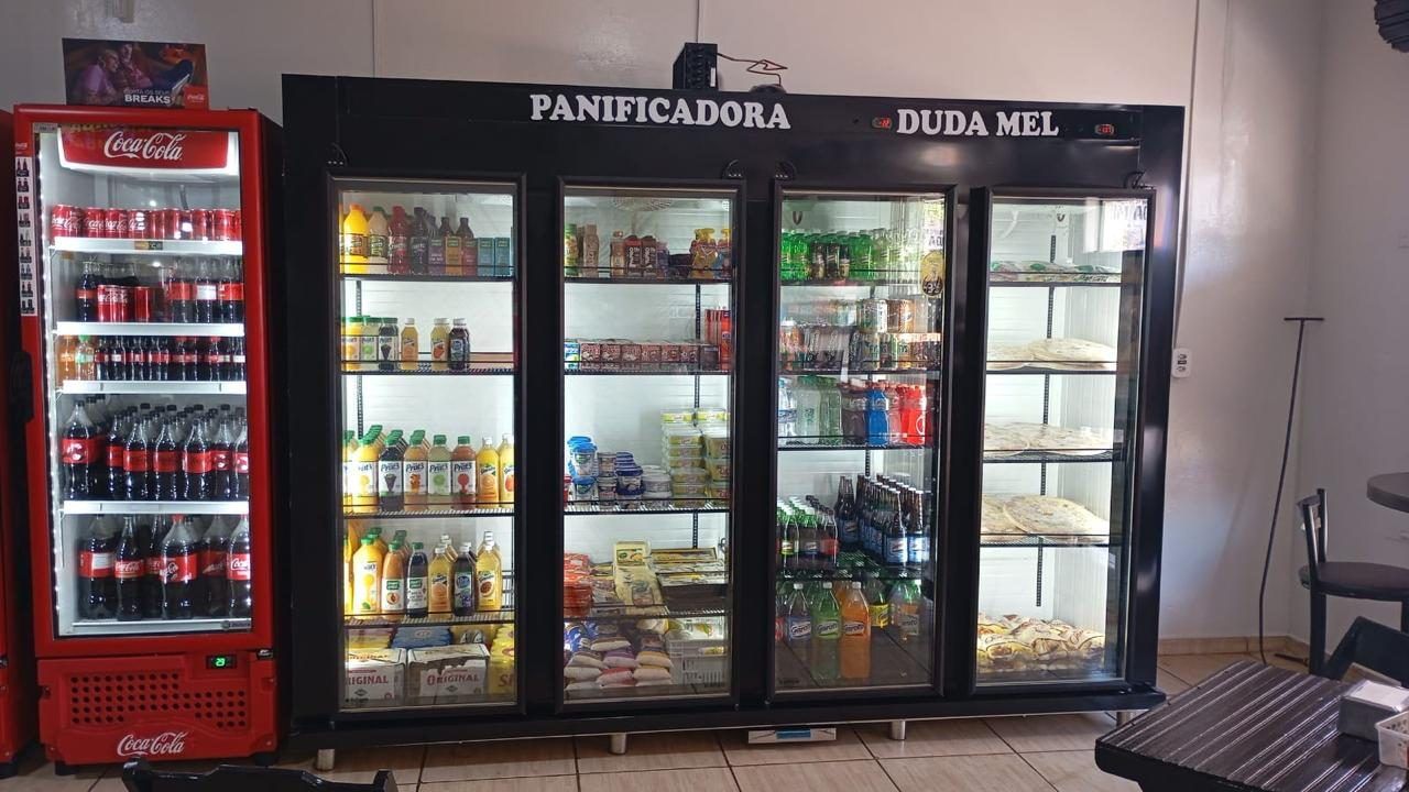Expositor refrigerado de quatro portas de vidro abastecido com bebidas em padaria